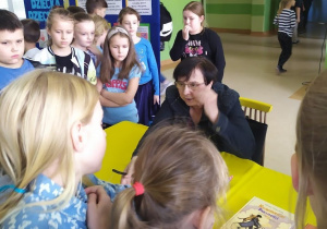 Autorka książek dla dzieci rozdaje autografy.