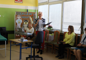 Dyrektor szkoły wręcza nagrody.