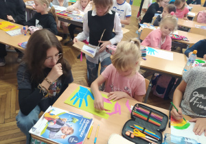 Uczennica klasy ósmej pomaga młodszej koleżance.
