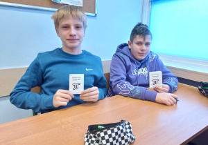 Uczniowie rozwiązują zadania w escape booku.