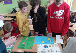 Uczniowie rozwiązują rebusy matematyczne.