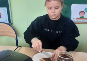 Uczennica przygotowuje tosta