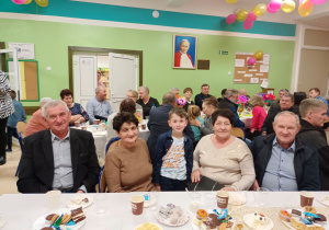 Babcie i Dziadkowie siedzą przy wspólnym poczęstunku