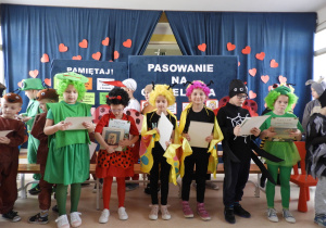 Uczniowie klas pierwszych z dyplomami i nagrodami książkowymi