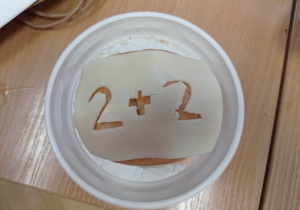Działania matematyczne wycięte w serze.