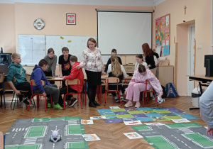 Uczniowie obserwują robota podczas jazdy.