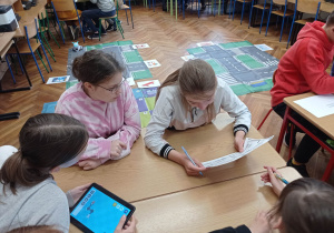 Uczennice klasy 7a rozwiązują zadania z potęg i pierwiastków i programują drogę robota.