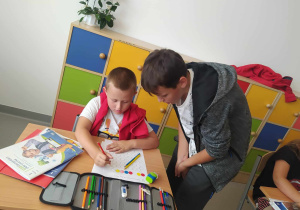 Uczeń klasy 8b pomaga rozwiązać zadanie koledze z młodszej klasy.
