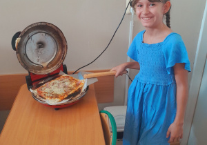 Uczennica piecze pizzę.