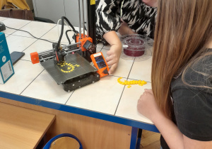 Pani edukator tłumaczy działanie drukarki 3D