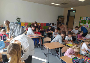 Klasa 8b pomaga uczniom klasy 1a w pracy plastycznej.
