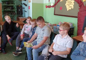 Uczeń klasy 2 czyta książkę głośno książkę dla kolegów