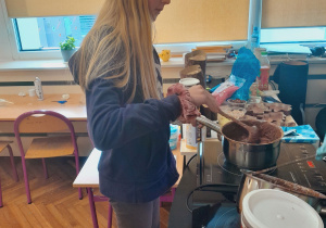 Uczennica przygotowuje topioną czekoladę