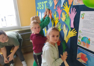 Uczniowie umieszczają na gazetce swoje "dłonie".