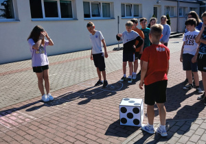 Uczniowie grają w grę planszową na świeżym powietrzu