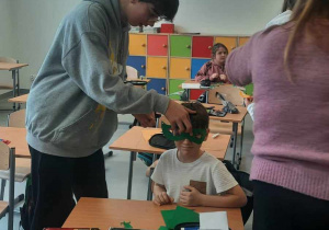 Uczeń przymierza koledze maskę