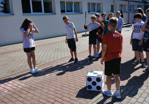 Uczniowie grają w grę planszową na świeżym powietrzu