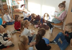 Uczennica czyta książkę młodszym koleżankom